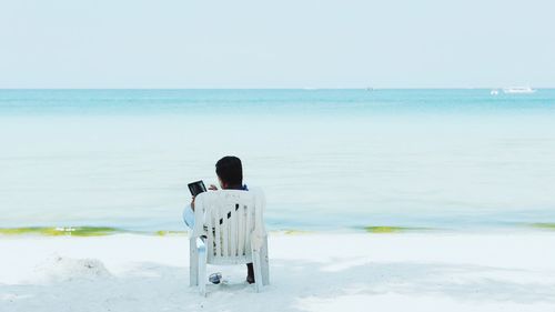 Woman using tablet on beach