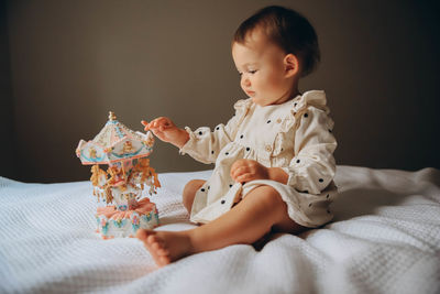 Close-up of cute baby girl lying on bed at home