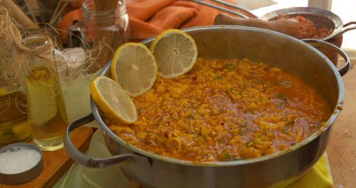 Seafood paella with lemon on kitchen table