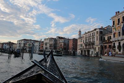 View of canal in city against sky