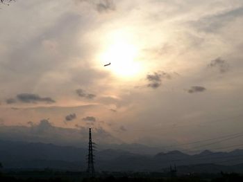 Silhouette birds on mountain against sky during sunset