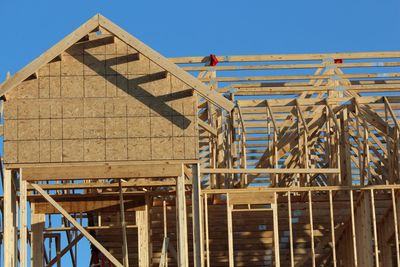 Wooden house frame against blue sky