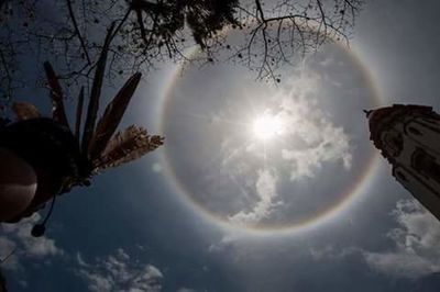 Low angle view of sun shining through clouds