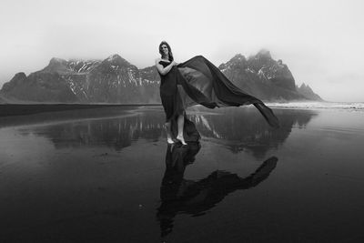 Happy lady wrapped with chiffon on beach monochrome scenic photography