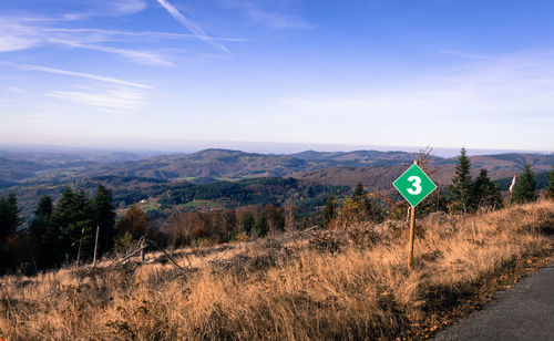 Information sign on landscape against sky