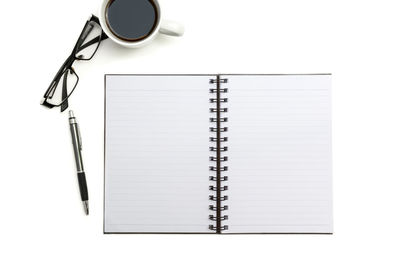 Directly above shot of book and pen against white background