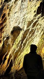 Rear view of man standing on rock formation