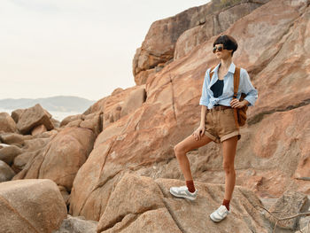 Full length of woman sitting on rock