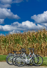 Bicycles on field against sky