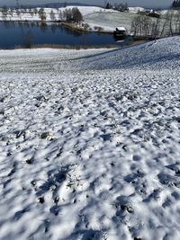 Frozen lake against snow covered landscape
