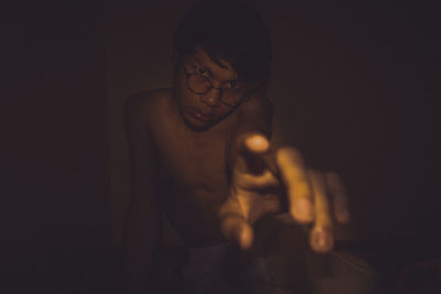 Young man looking away against black background