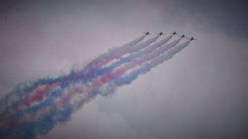 Low angle view of airshow against sky