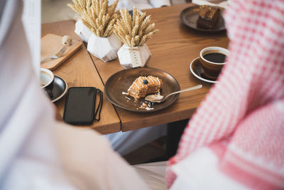 High angle view of woman with coffee cup on table