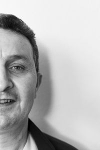 Close-up portrait of smiling man against wall