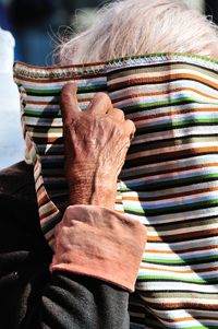 Close-up of man covering face with colorful fabric