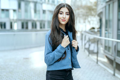 Teenage girl posing in city while look neutral into camera with make up 