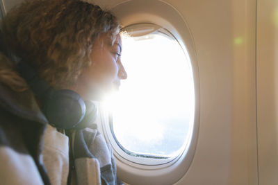 Young woman looking out of airplane window