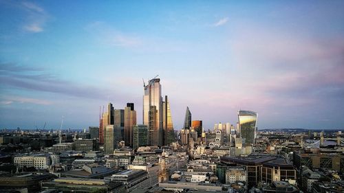 Modern buildings in city against cloudy sky