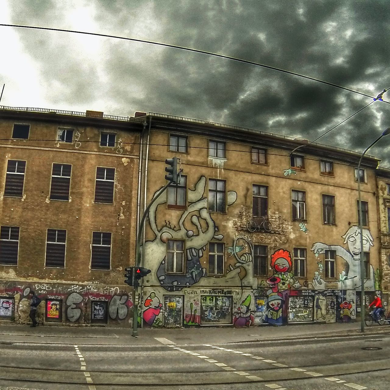 building exterior, architecture, built structure, sky, street, city, cloud - sky, transportation, graffiti, building, city life, road, art and craft, city street, art, cloudy, land vehicle, incidental people, outdoors, cloud