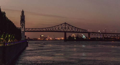 Bridge over river in city at night