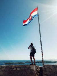 Boy looking at sea against sky