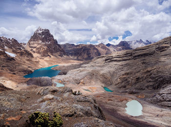 Scenic view of lake and mountains against cloudy sky