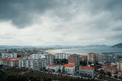 High angle view of buildings against sky in city next to beach