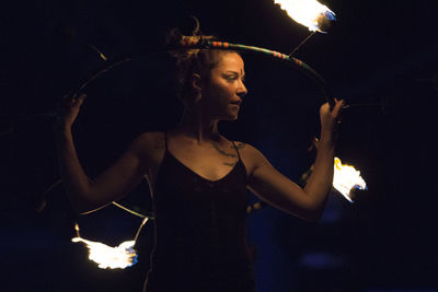 Reflection of young woman in illuminated light painting at night