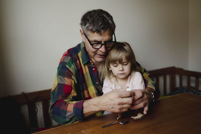 Grandfather with granddaughter at table
