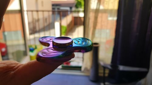 Cropped hand spinning fidget spinner against window