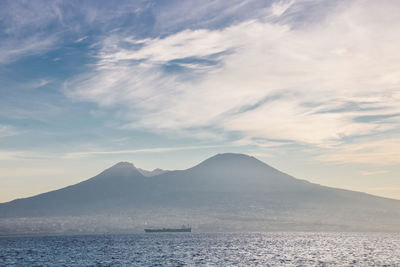 Scenic view of sea and mountains against sky