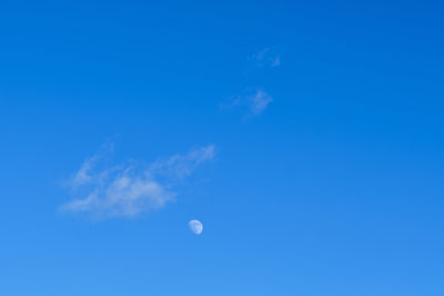 Low angle view of moon against blue sky