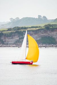 Sailboat sailing on sea against sky