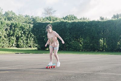 Young girl on a skateboard at a basketball court