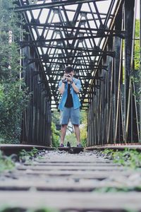 Surface level of man photographing on railroad tracks