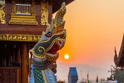 Low angle view of statue of woman against sky during sunset