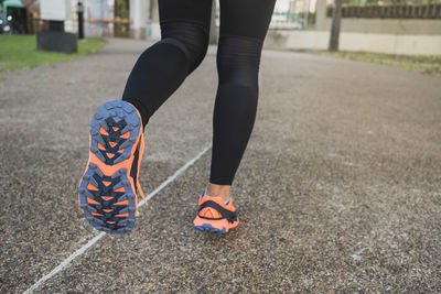 Low section of woman running on road