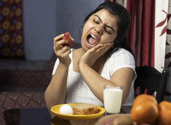 Young woman sitting on table at home