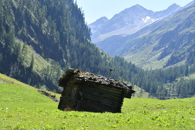 Built structure on field against mountains