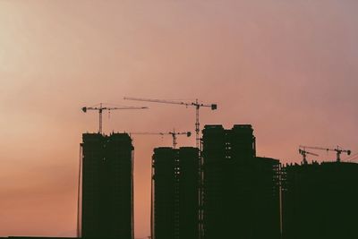 Low angle view of cranes at construction site