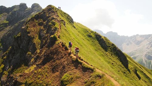 People on mountain against sky