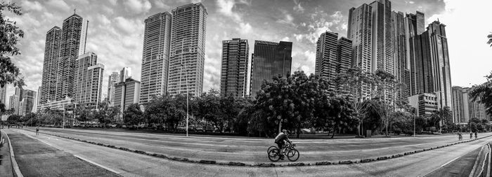 Panoramic view of panama street cinta costera with  2 cyclist in black and white 