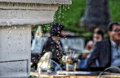 Reflection of people on wet window in rainy season