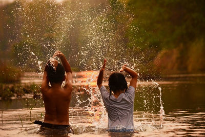 Rear view of boys playing in water