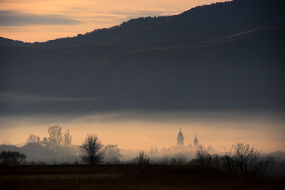 Scenic view of silhouette mountains during foggy weather