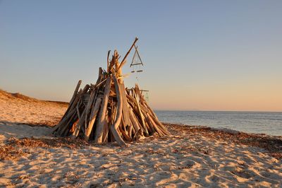 Scenic view of beach against clear sky during sunset