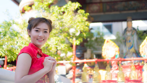 Portrait of smiling young woman standing outdoors