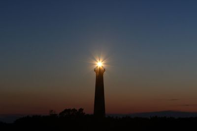 Low angle view of illuminated tower against sky during sunset