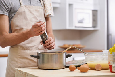 Midsection of man working in kitchen