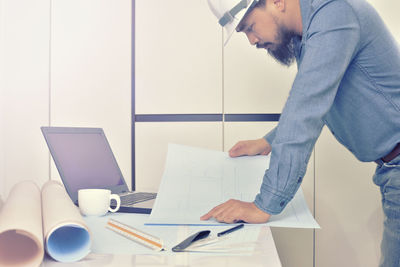 Side view of man working on table